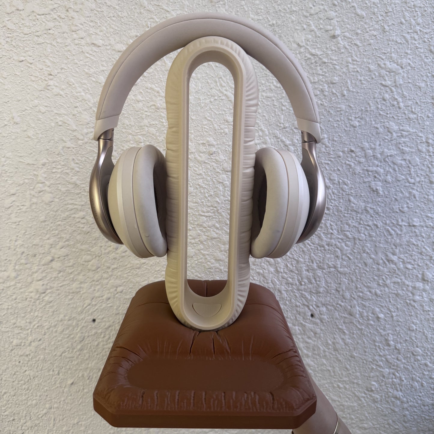 Cushion Headspace in beige-brown holding headphones, front view