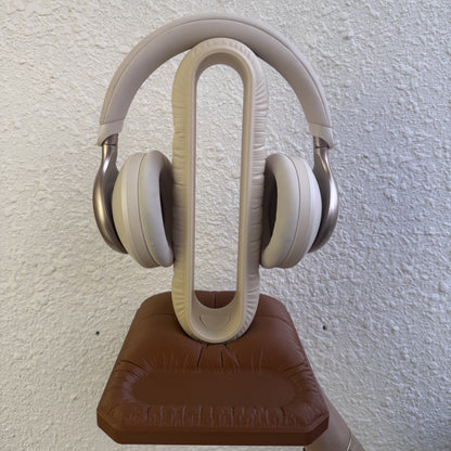 Cushion Headspace in beige-brown holding headphones, front view