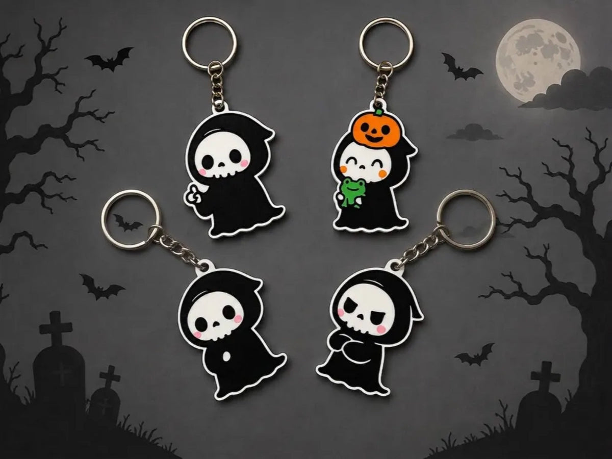 Four Halloween ghost keychains - all designs on a graveyard backdrop