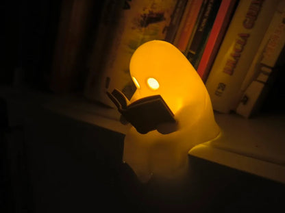 Studious Ghost - a ghost tealight reading a tiny book, glowing eyes on the page (primary)