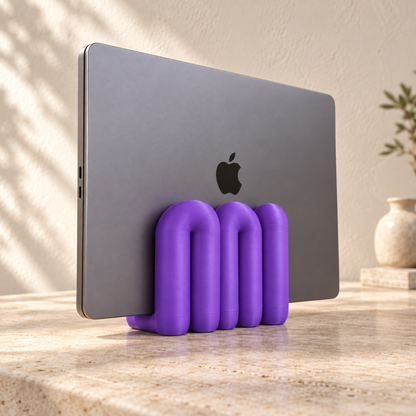 The Loop Stand in purple holding a closed grey laptop, left three-quarter view