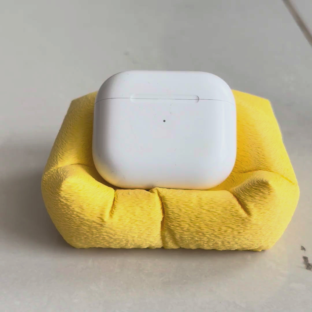 Cushion Bean AirPod Stand — holding an AirPods case