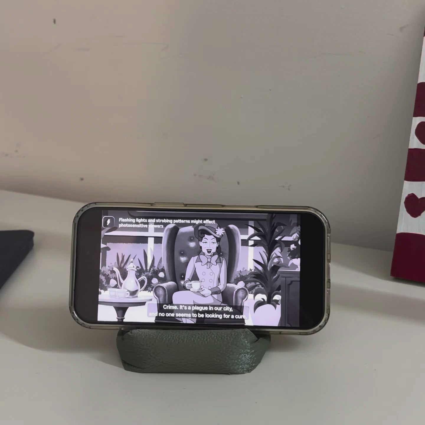 Cushion Bean Pod holding a phone playing a video