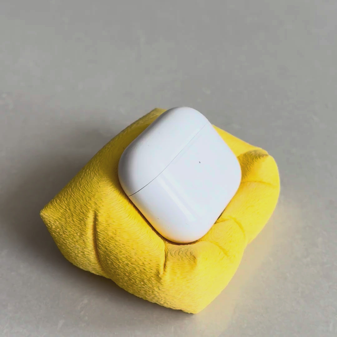 Cushion Bean AirPod Stand — holding an AirPods case