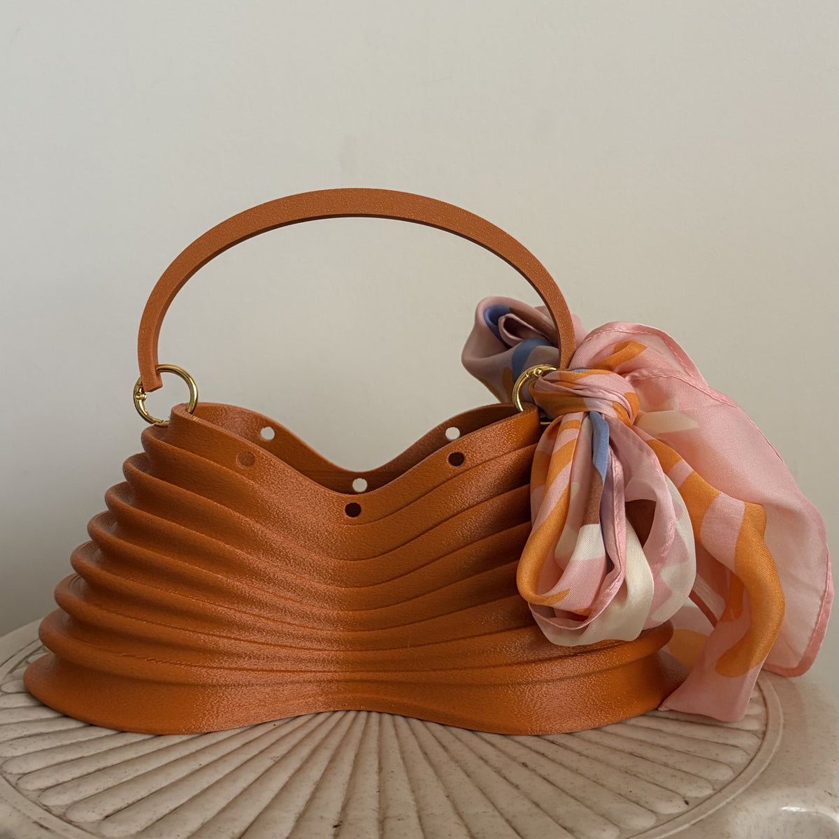 Thorax Bag on a stool, front three-quarter view with silk scarf
