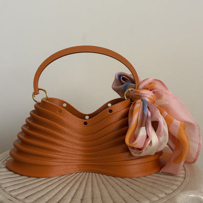 Thorax Bag on a stool, front three-quarter view with silk scarf
